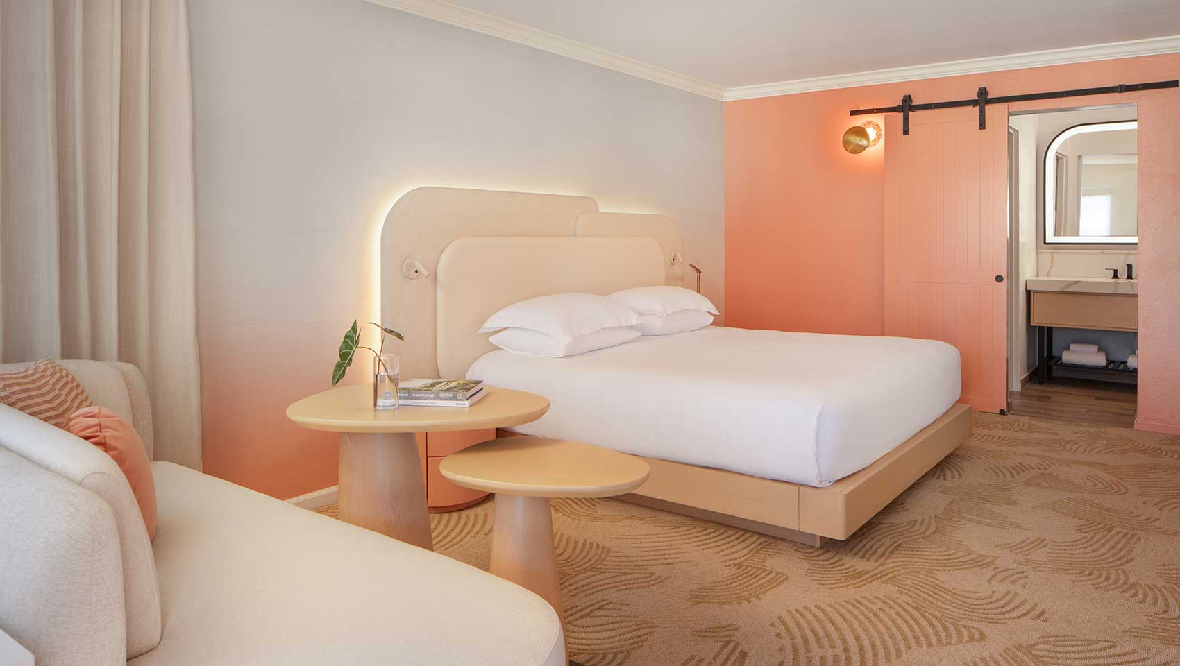 King bed with couch and bathroom view in Miralina guestroom