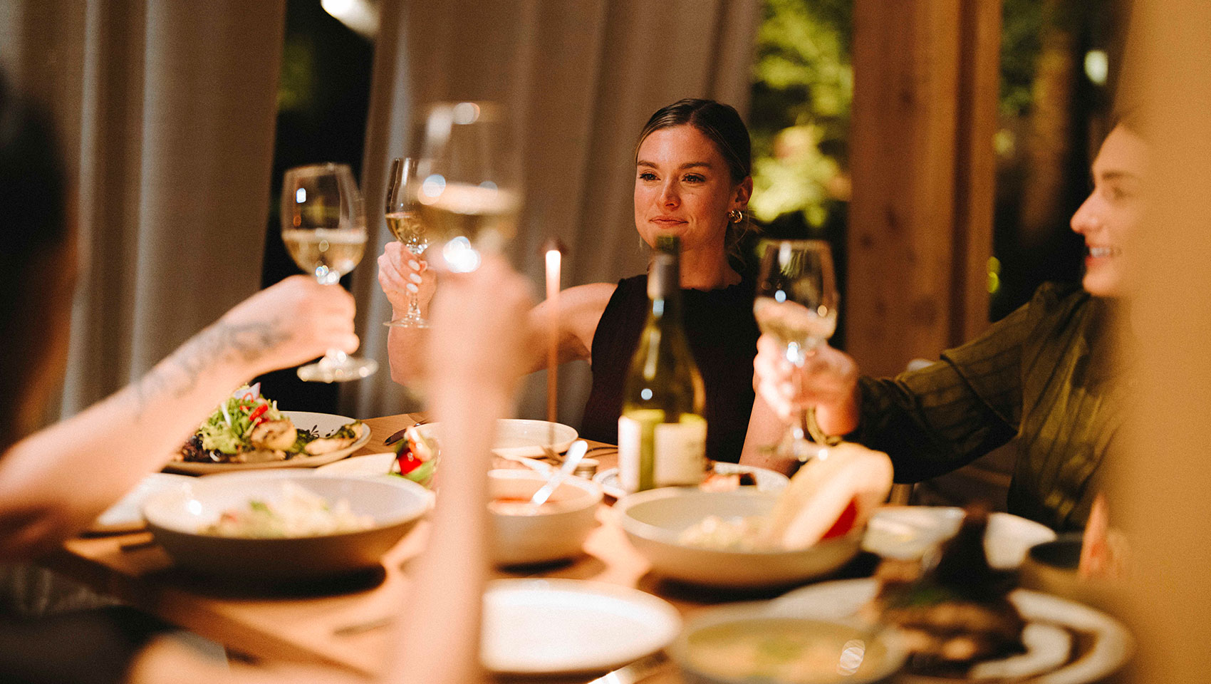 woman doing a wine cheers at dinner at Hecho Libre