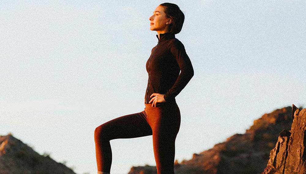 Woman stands on mountain looking out