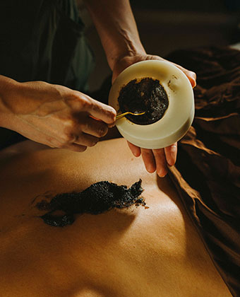 massage practitioner putting mud on someone