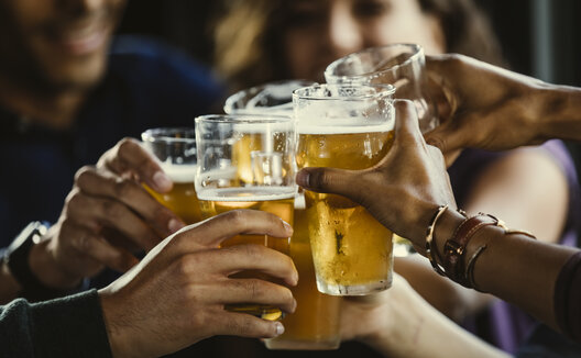 hands cheersing with beers in glasses