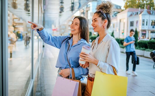 two women window shopping and holding shopping bags