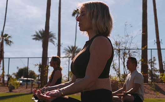 woman does outdoor yoga at Kimpton Miralina