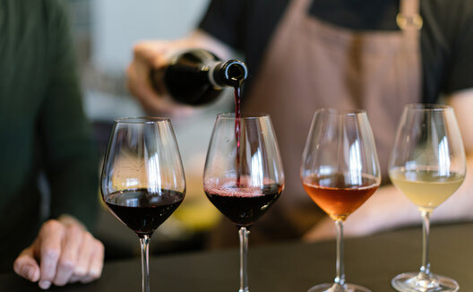 four glasses of wine lined up darkest to lightest